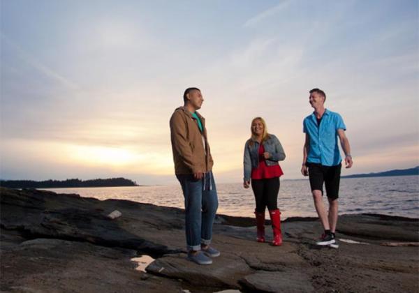 Three people standing on a beach