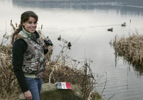 Young woman standing by a body of water