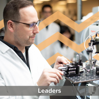 Young man with glasses and a lab coat working in a lab