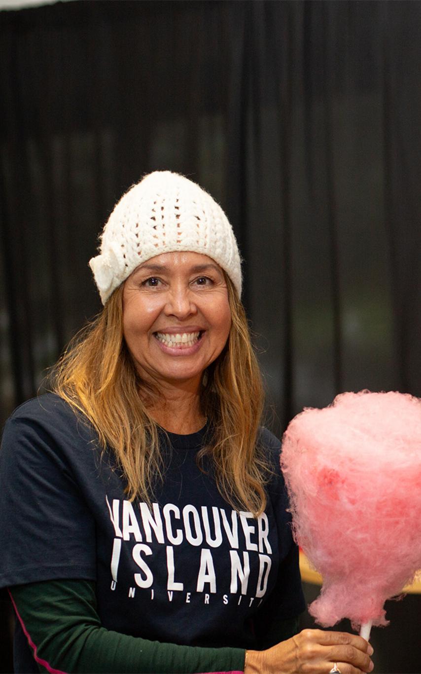 Smiling woman in VIU sweatshirt holding cotton candy.